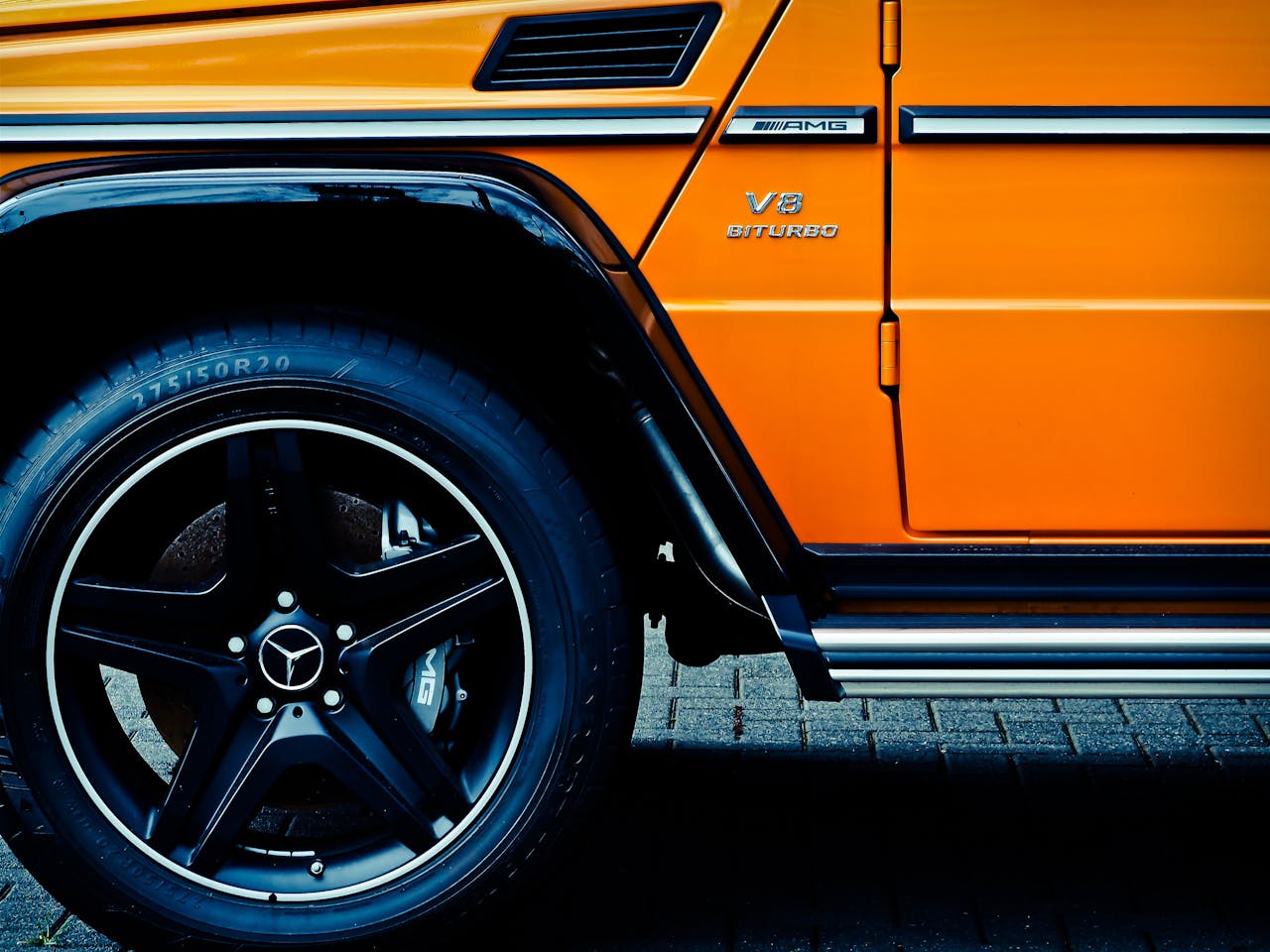 Detailed view of a luxury SUV's wheel and tire, showcasing design elements.